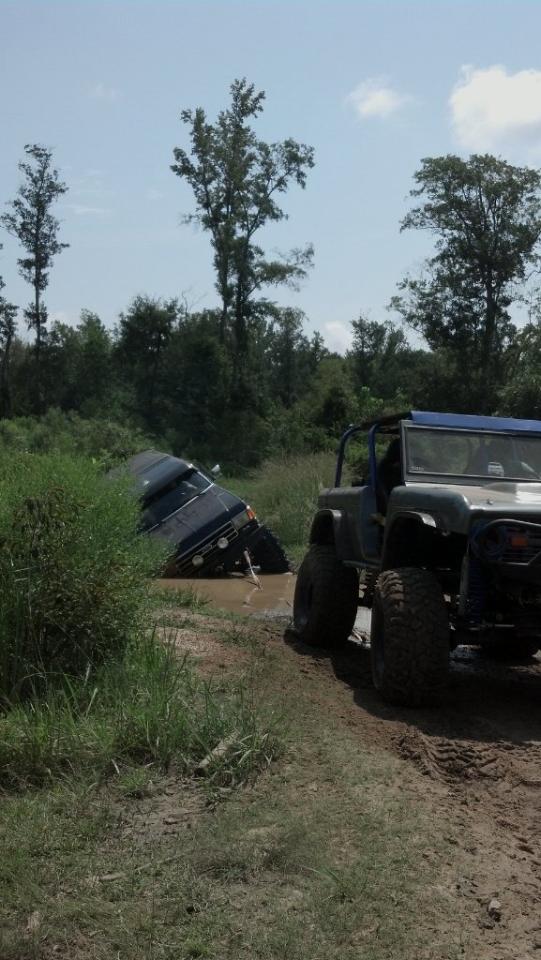 1990 Ford Bronco and another SUV stuck in mud
