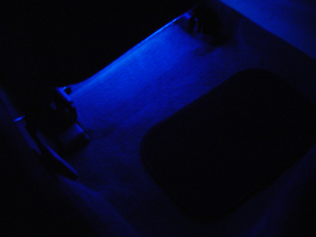Interior car floor with blue LED lighting and a dark rectangular mat