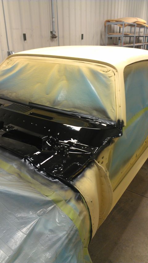 1973 Chevrolet Camaro - The windshield cowl of a car is being painted black, with the rest of the vehicle covered in protective plastic sheeting.