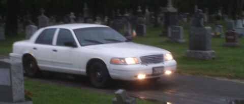 1998 Ford Crown Victoria - White 1998 Ford Crown Victoria seen driving through a cemetery.