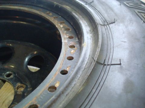 1995 Ford Bronco - A close-up view of a tire's bead and a rusty wheel rim with visible bolt holes.