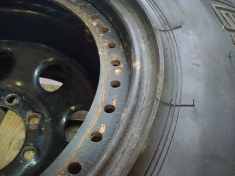 1995 Ford Bronco - Close-up of a rusty beadlock wheel rim and tire, showing wear and tear.