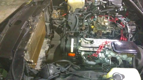 1973 Chevrolet Camaro - Engine bay of a car, showing the radiator and engine block with various hoses and wires.