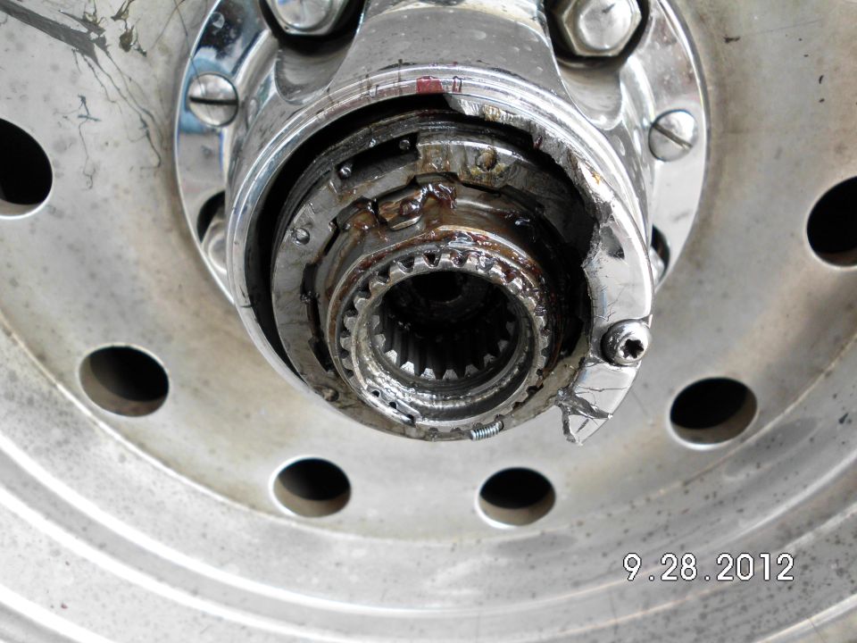Close-up of a damaged wheel hub assembly with visible splines and metal fatigue