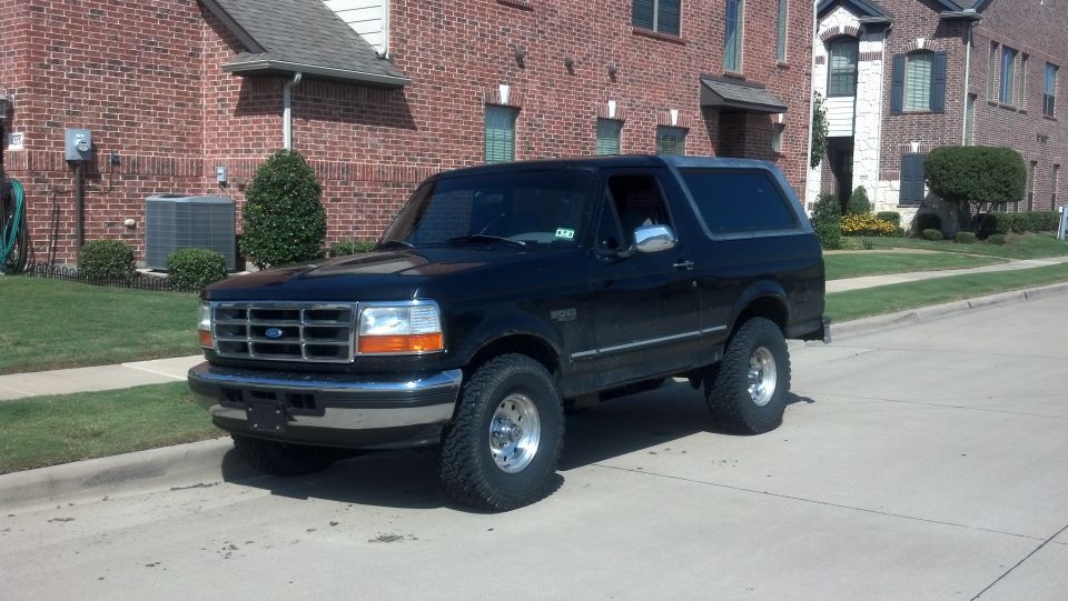 1996 Ford Bronco parked on street in front of brick building