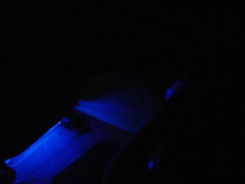 1999 Ford Taurus - Blue underglow lighting illuminates the interior of a car, casting shadows on the dashboard and floor.