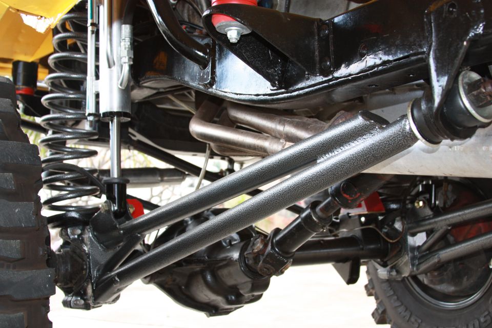 Close-up of off-road vehicle suspension with heavy-duty shocks, springs, and differential