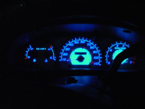 1999 Ford Taurus - Interior view of a car's illuminated dashboard gauges at night.