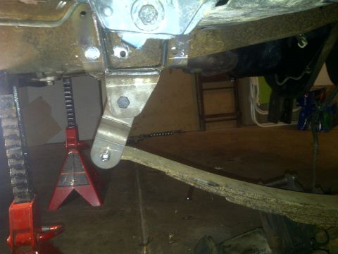 1995 Ford Bronco - Close-up view of vehicle suspension components and jack stands, likely during maintenance or repair.