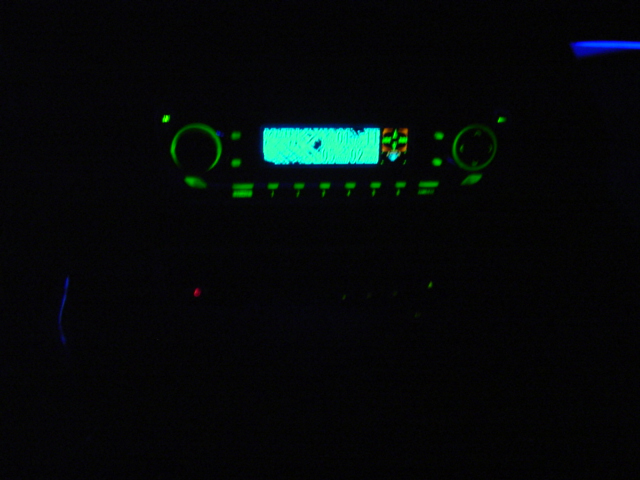 car stereo with glowing green display and buttons