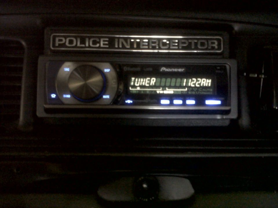 Police Interceptor badge above Pioneer car stereo with tuner display