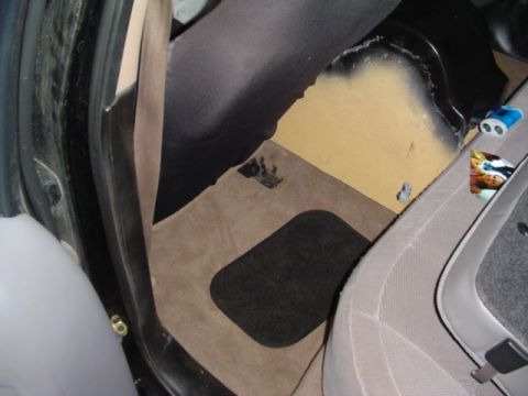 1999 Ford Taurus - Interior view of a car's floor, revealing carpet, a floor mat, and seat details.