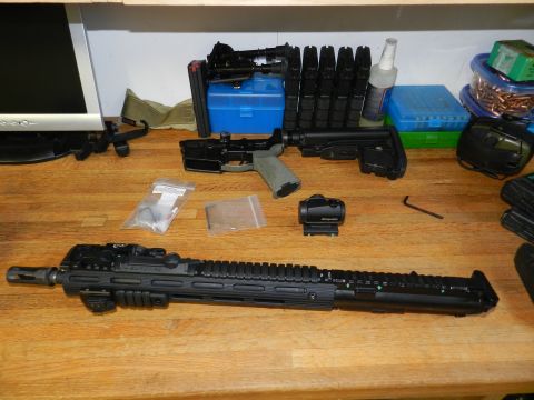 1996 Ford Bronco - Various firearm components, including an AR-15 lower receiver and upper assembly, are laid out on a table.