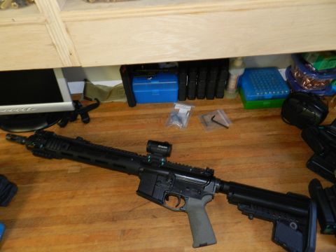 1996 Ford Bronco - An assault rifle with accessories is laid out on a wooden table next to various storage containers.