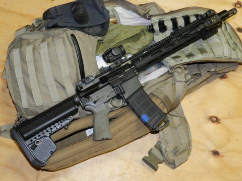 1996 Ford Bronco - Tactical rifle and gear laid out on a wooden surface.