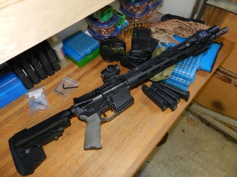 1996 Ford Bronco - A rifle and ammunition are laid out on a wooden surface.