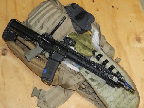 1996 Ford Bronco - An assault rifle with various tactical attachments is laid out on a camouflage backpack.
