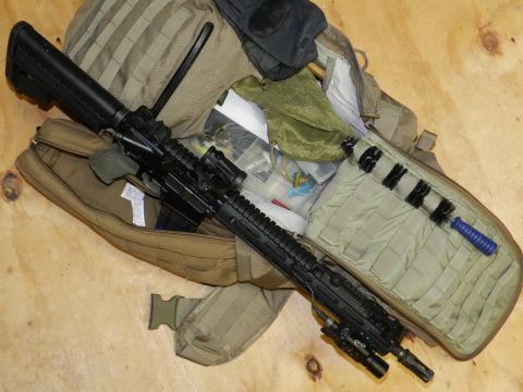 1996 Ford Bronco - A rifle, cleaning kit, and fishing tackle are organized within a tactical backpack.