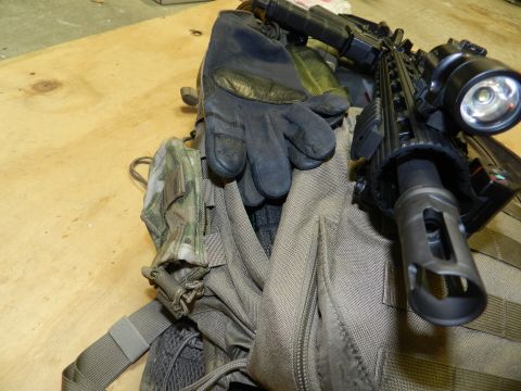 1996 Ford Bronco - Tactical gear including gloves and a rifle barrel with accessories is laid out on a wooden surface.