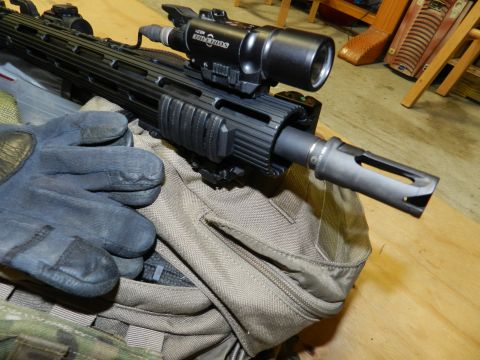 1996 Ford Bronco - Close-up of a rifle's barrel and accessories, resting on a bag with gloves nearby.