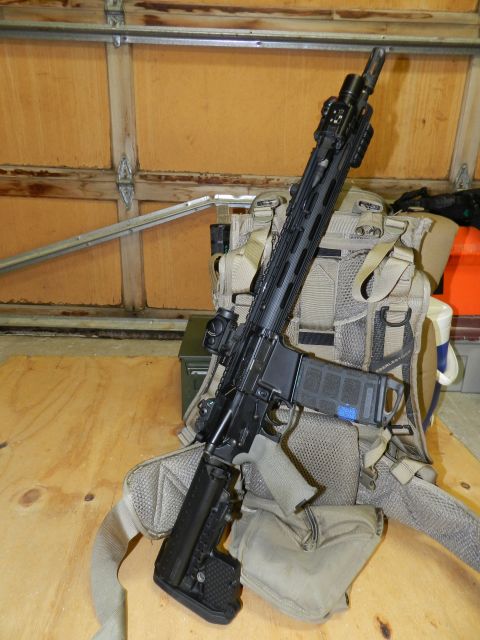 1996 Ford Bronco - A rifle is positioned over a tactical vest, set against a wooden background.