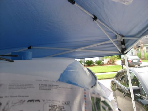 1994 Ford Bronco - A car's interior is partially covered by a blue tarp and papers, with pens nearby.