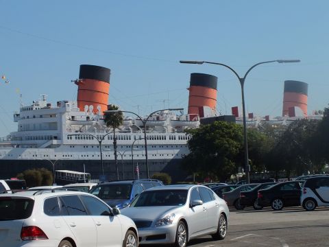 2003 Ford Crown Victoria - Retired ocean liner with three orange-and-black funnels seen over a parking lot of cars