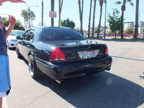 2003 Ford Crown Victoria - Rear of a slammed black Crown Victoria showing dual exhaust tips and an EVIL VIC vanity plate.