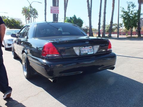 2003 Ford Crown Victoria - Straight-on rear of a black Crown Victoria sedan with dual exhaust and EVIL VIC plate.