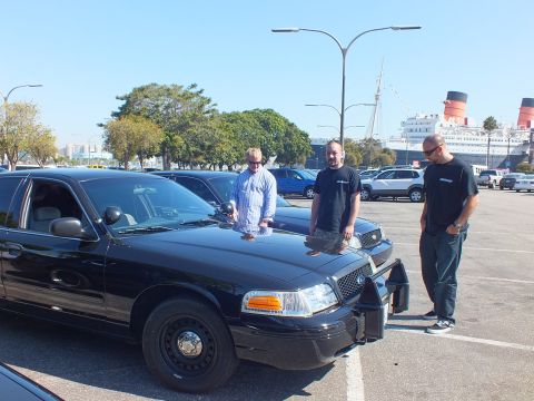 2003 Ford Crown Victoria - Three men pose beside a black Crown Victoria, the Queen Mary's funnels visible behind them.
