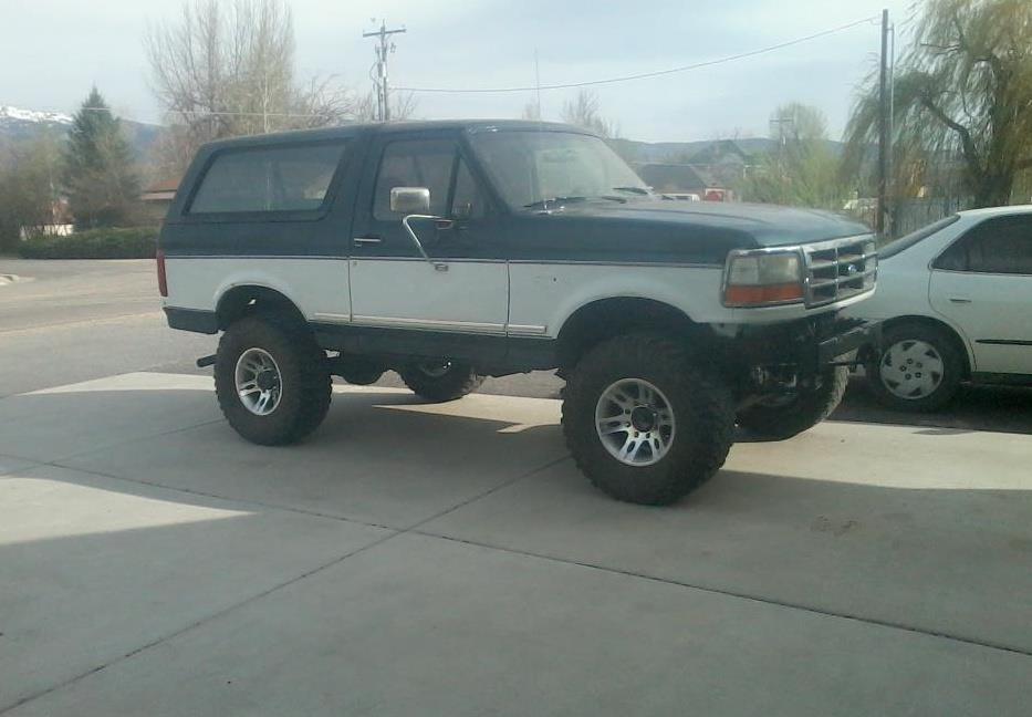 Lifted 1994 Ford Bronco, dark blue and white, 3/4 front view