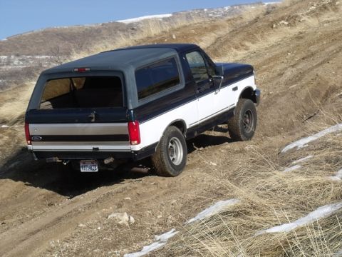 1994 Ford Bronco - This two-tone black and white Ford Bronco is captured from the rear as it navigates a dirt incline.