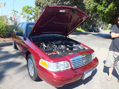 2003 Ford Crown Victoria - Dark red Ford Crown Victoria parked with hood raised; a person stands beside the front fender.