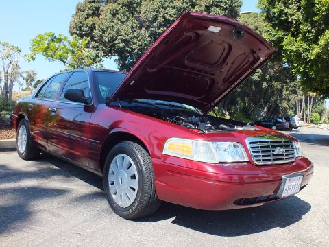 2003 Ford Crown Victoria - Maroon Ford Crown Victoria photographed front three-quarter with raised hood and Ford oval grille.