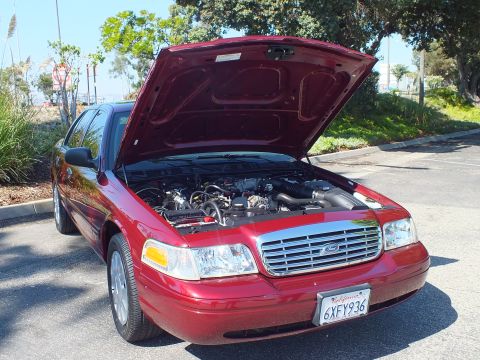 2003 Ford Crown Victoria - Dark red Ford Crown Victoria sedan parked with hood up, front plate reads 6XFY936.
