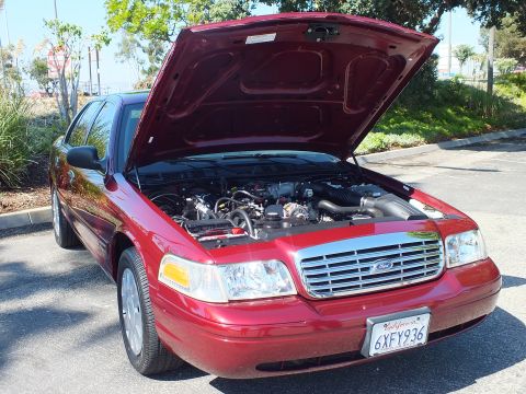2003 Ford Crown Victoria - Maroon Ford Crown Victoria shown front three-quarter with raised hood and plate 6XFY936.