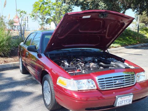 2003 Ford Crown Victoria - Dark red Ford Crown Victoria parked with open hood exposing the V8; California plate 6XFY936.