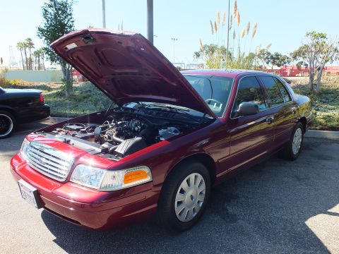 2003 Ford Crown Victoria - Maroon Ford Crown Victoria parked with hood raised near landscaping and palm trees.