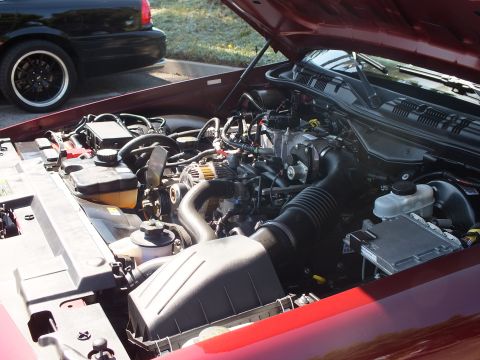 2003 Ford Crown Victoria - Under-hood view of a dark red Ford with the V8, air filter housing and reservoir visible.