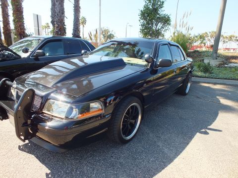 2003 Ford Crown Victoria - Front three-quarter of a black Crown Victoria fitted with a push bumper and dark grille.