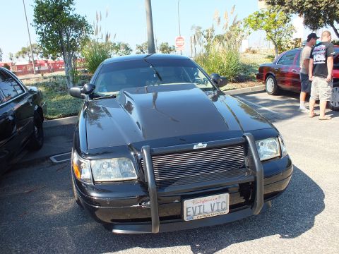 2003 Ford Crown Victoria - Angled front view of a black Crown Victoria with push bumper and EVIL VIC plate.