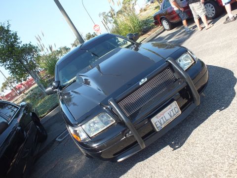 2003 Ford Crown Victoria - Low front-quarter angle of a black Crown Victoria with push bumper and EVIL VIC plate.