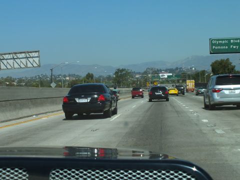 2003 Ford Crown Victoria - Multi-lane highway view past green exit signs for Olympic Blvd and Pomona Fwy