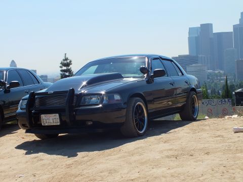 2003 Ford Crown Victoria - Lowered black sedan with grille guard parked on dirt above downtown LA