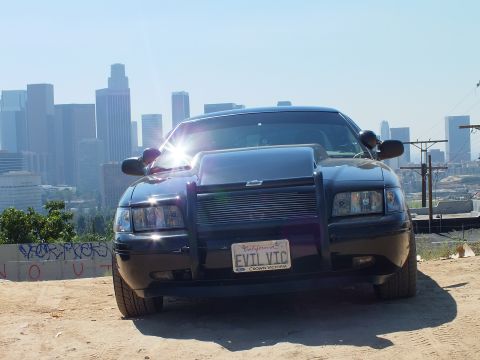 2003 Ford Crown Victoria - Front of a black Crown Victoria with billet grille and brush guard; California plate reads EVIL VIC.