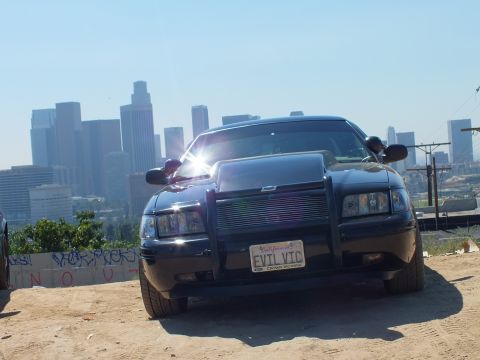 2003 Ford Crown Victoria - Lowered black Crown Victoria with billet grille and push bar, EVIL VIC plate, downtown LA in the haze.