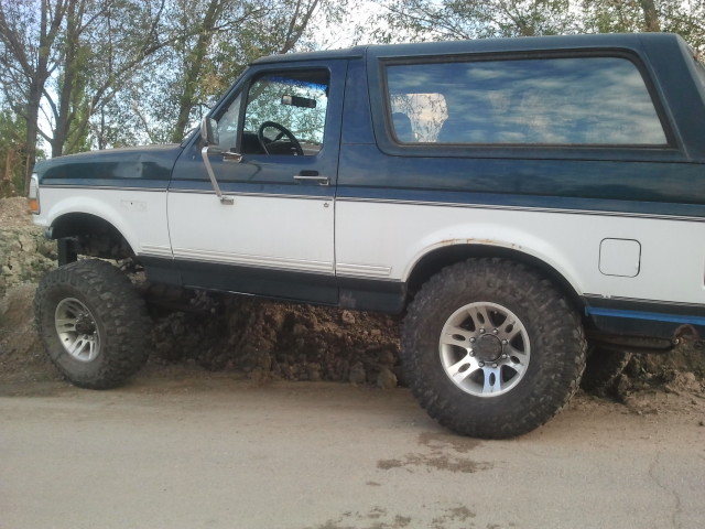 1994 Ford Bronco with lifted suspension and large tires on dirt