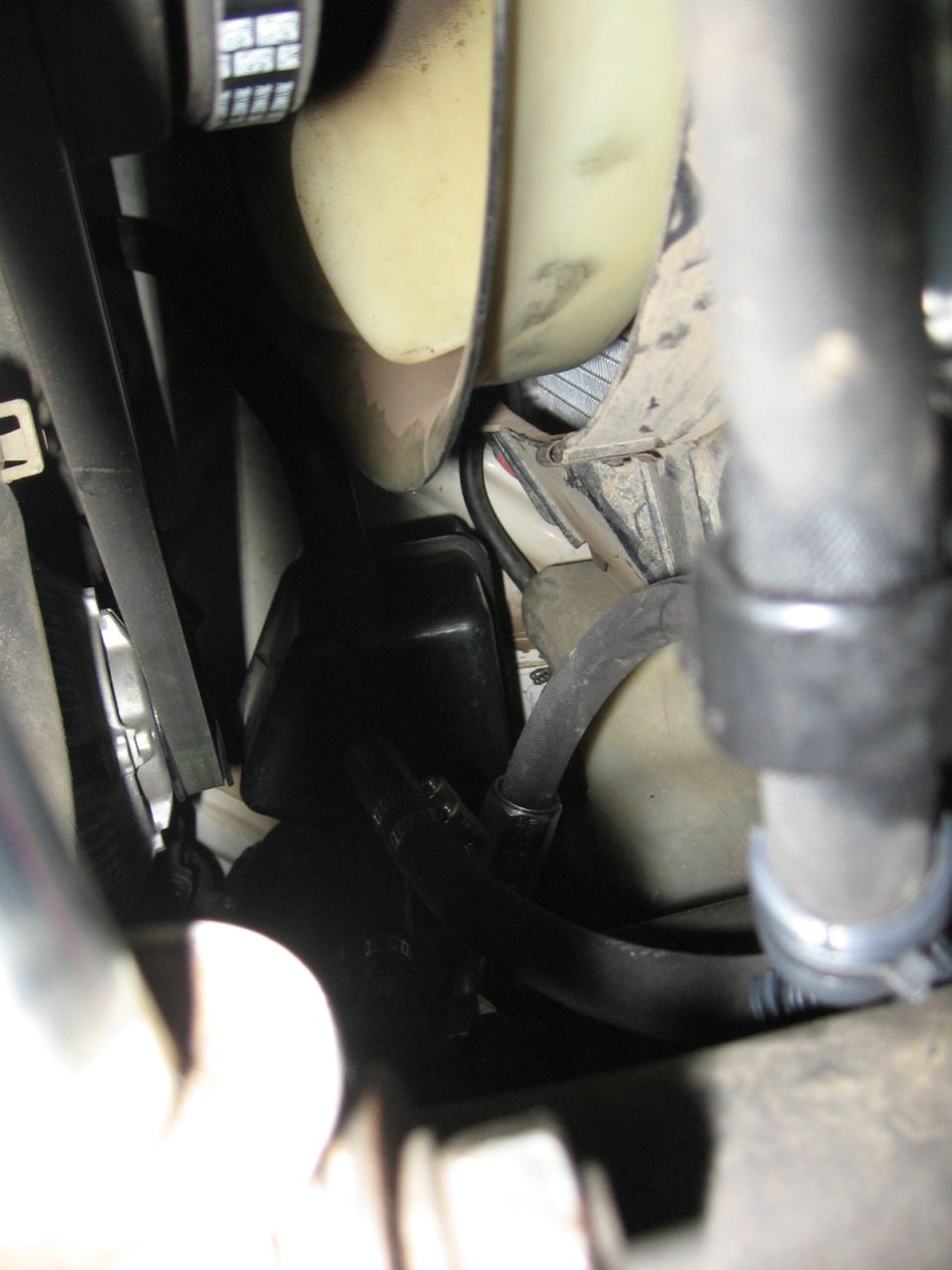 Engine bay with fan, hoses, and black plastic cover