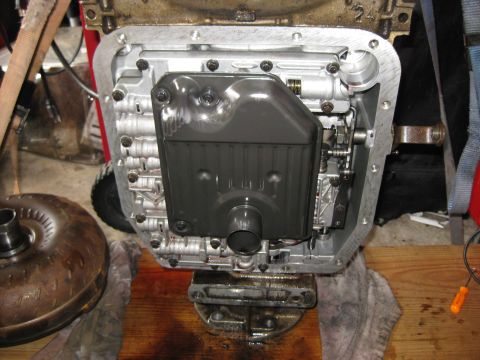 1994 Ford Bronco - The transmission is standing on its end on a stand with cutouts for the tailshaft and dowel pin. it is strapped to the the stand with tie d…