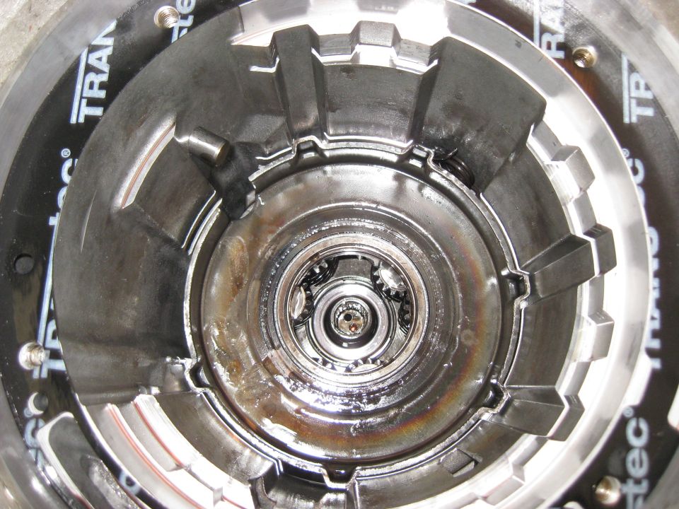 Close-up of transmission torque converter with 'TRAN' visible on gasket